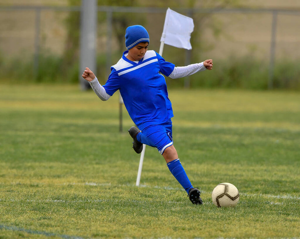 Athletischer kleiner Junge macht erstaunliche Spiele während eines Fußballspiels - Foto, Bild