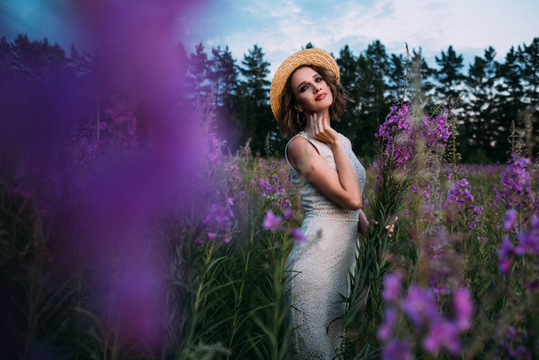 a girl in a straw hat in a field of flowers - Foto, afbeelding
