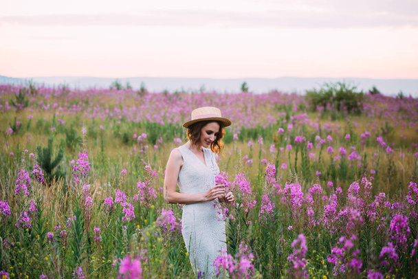 a girl in a straw hat in a field of flowers - Foto, Imagen