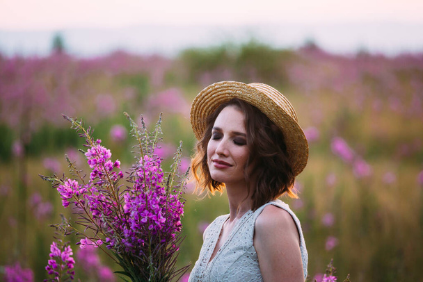 a girl in a straw hat in a field of flowers - Foto, afbeelding