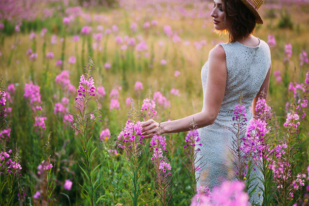 a girl in a straw hat in a field of flowers - Foto, immagini