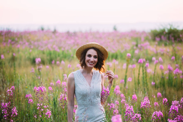 a girl in a straw hat in a field of flowers - Foto, Imagem