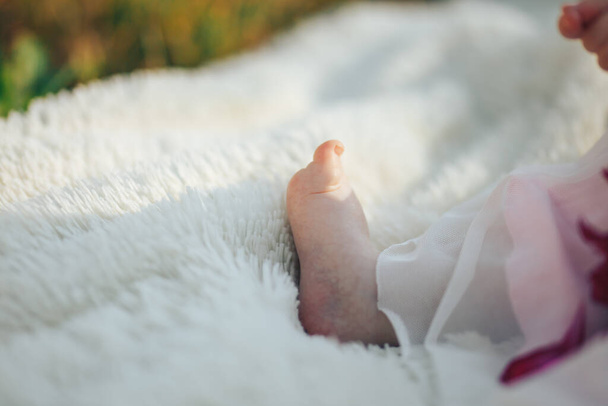 Μικρό πόδι νεογέννητου μωρού, υπαίθριο στο πάρκο - Φωτογραφία, εικόνα