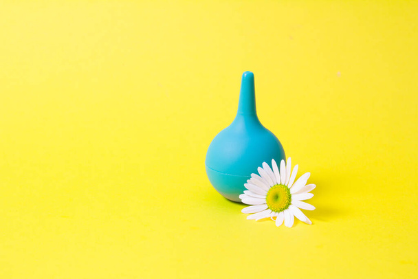 green small enema and chamomile on yellow background - 写真・画像