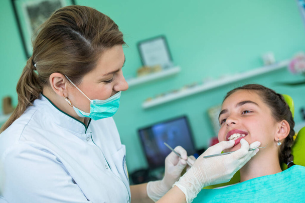 Женщина-дантист и молодая пациентка в кабинете дантиста   - Фото, изображение