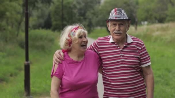 Ein älteres kaukasisches Paar, das sich im Park umarmt. Älterer Mann geht mit Frau. Mann, Frau - Filmmaterial, Video
