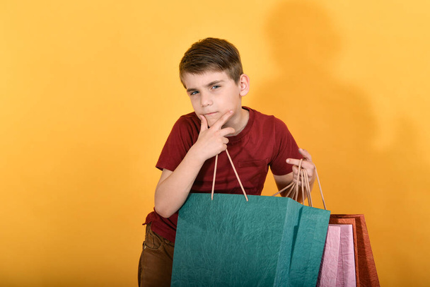 Un chico con una cara feliz está de pie después de comprar productos
. - Foto, imagen