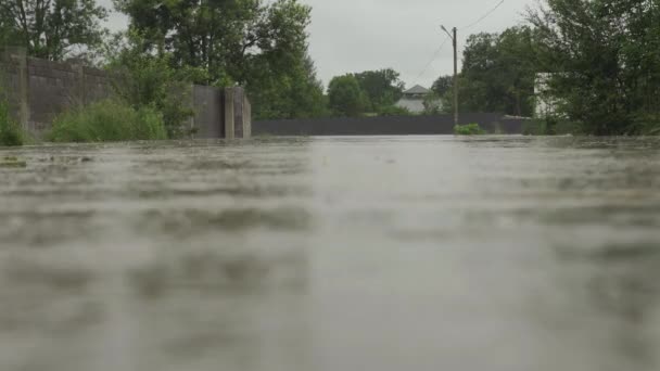 Überflutete Straße bei Überschwemmungen. Wasser überflutete die Straße und den Zaun eines Privathauses. Es regnet und der Wasserspiegel steigt. Limnitsa-Fluss Ukraine. - Filmmaterial, Video
