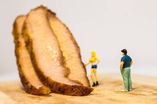 Miniature people, Close up fat man with grilled pork neck on white background with copy space - Photo, Image