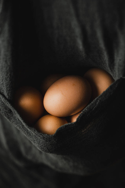 Verse biologische eieren op handen van jonge boeren - Foto, afbeelding