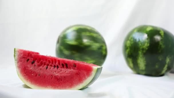 Egész görögdinnye fonódik a szeletelt görögdinnye hátán - Felvétel, videó
