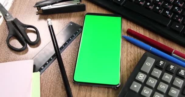 Зеленый экран смартфона на рабочем столе вид сверху - Кадры, видео