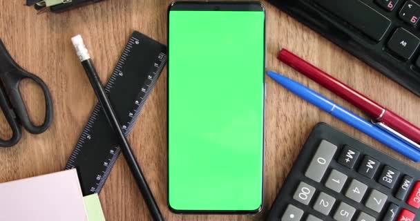 Smartphone pantalla verde en la mesa de la oficina vista superior zoom en
 - Imágenes, Vídeo