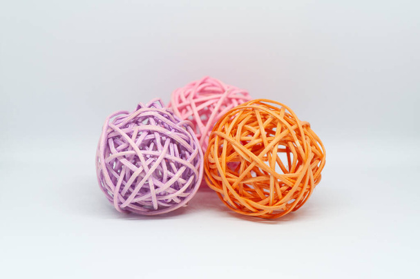Dry reeds designed into three pink orange and lilac balls for decoration on white background - Zdjęcie, obraz