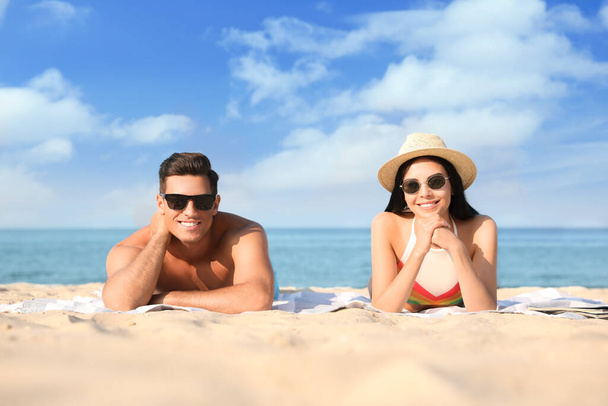 Happy couple resting on sunny beach at resort - Photo, image