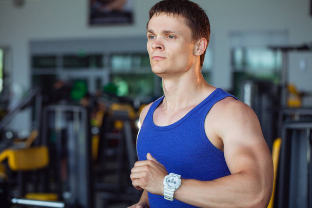 Strong man, bodybuilder exercising in a gym - Фото, изображение
