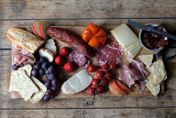 Home celebração frios carnes e queijo bordo com frutas e legumes
 - Foto, Imagem