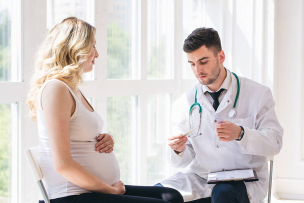 Doctor is measure the temperature of pregnant woman - Valokuva, kuva