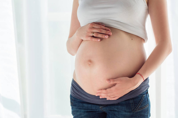 Pregnant woman touching her belly - Fotó, kép