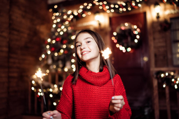Portrait of a child girl looks with sparklers in their hands - 写真・画像