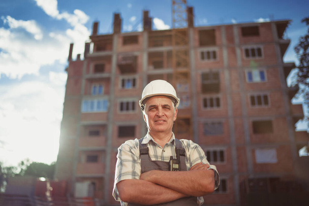 Portrait senior engineer at a construction site. Sunset time - Zdjęcie, obraz