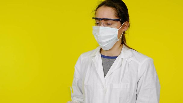 Молодой врач в защитной медицинской маске, очках и белом халате
 - Фото, изображение