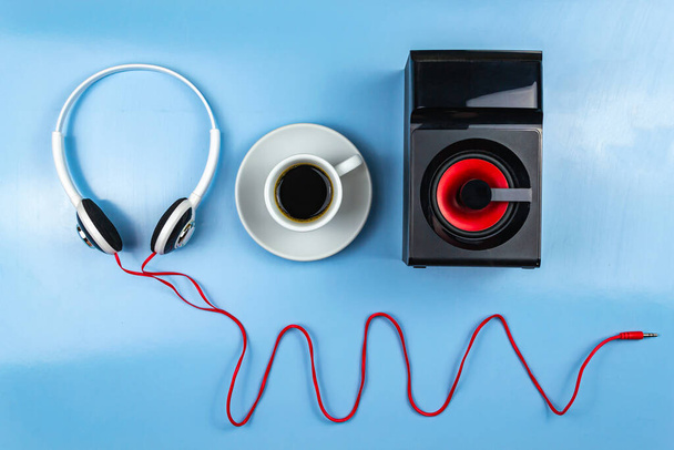 Колона, навушники, смартфон і чашка кави. Синій фон крупним планом
 - Фото, зображення