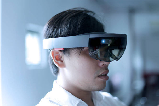 asiatico business uomo indossare hololens occhiali per esperimento misto realtà - Foto, immagini