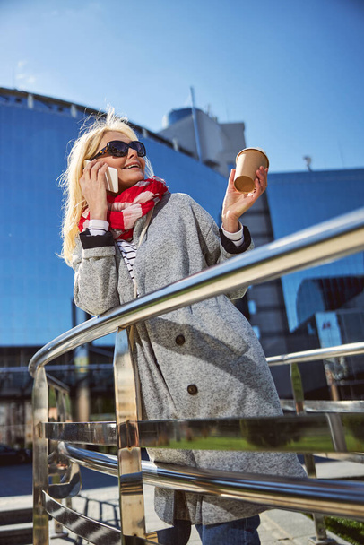 Feliz dama caucásica en gafas de sol negras pasar tiempo al aire libre
 - Foto, Imagen