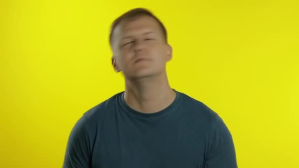 Portret van een jonge blanke die poseert in een groen t-shirt. Grappige knappe man schudt zijn hoofd, glimlachend - Video
