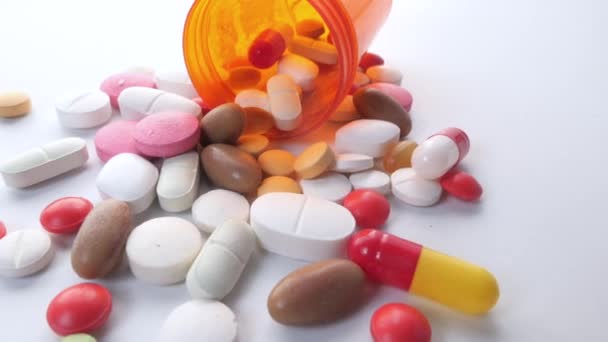 közeli-ból színes tabletták ömlött fehér háttér  - Felvétel, videó
