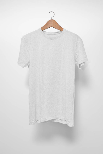 Wit T-Shirt op een hanger tegen een witte achtergrond - Foto, afbeelding
