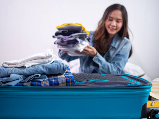 donne o turisti stanno imballando i vestiti in borse per le lunghe vacanze o vacanze. prepararsi a viaggiare - Foto, immagini