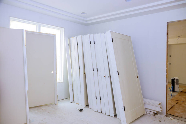 Vnitřní dřevěné stohovací dveře a čekací instalace pro přípravu interiéru v novém domově - Fotografie, Obrázek