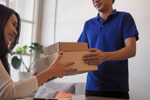 Woman accepting on line shopping  product  from  home delivery man. Service concept, Quick and convenient. Stay home and Buy products online. - Foto, immagini