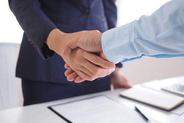 Deux hommes d'affaires se serrent la main après avoir négocié l'accord et signé le contrat. - Photo, image