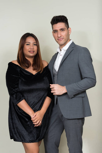 Portrait of overweight Asian businesswoman and young businessman as couple together - Foto, imagen