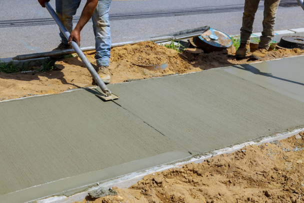 Processo de instalação de construção de novas calçadas que colocam cimento de concreto - Foto, Imagem