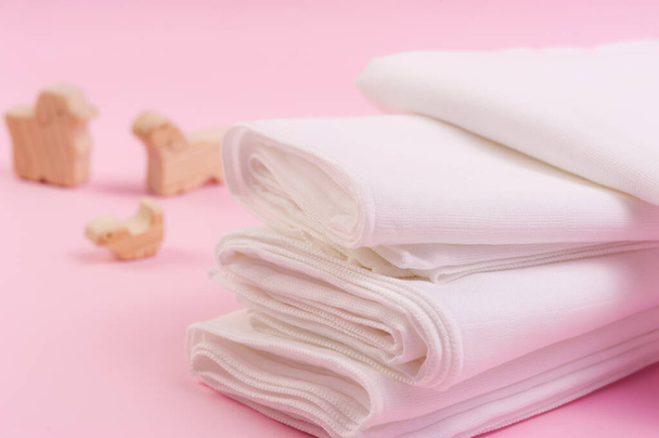 lähikuva valkoinen ja pehmeä vauvan kangas vaipat vaaleanpunainen tausta - Valokuva, kuva