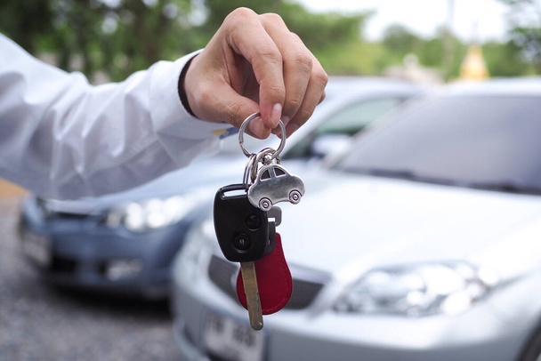 Il venditore invia le chiavi dell'auto al noleggiatore per l'uso in viaggio. Vendita e noleggio auto - Foto, immagini