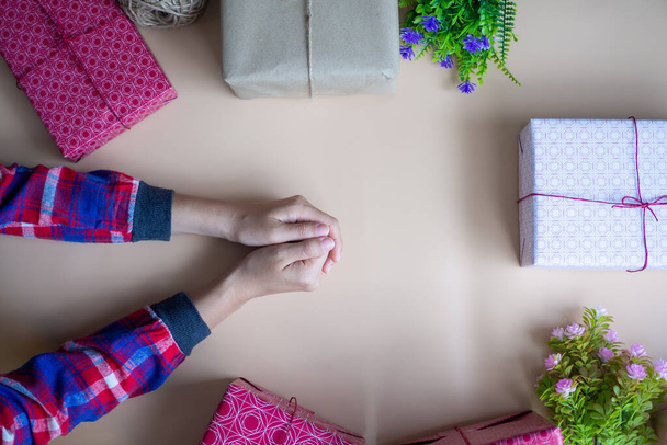 La mano de la niña con la caja de regalo colocada sobre la mesa. concepto de tiempo feliz
 - Foto, Imagen