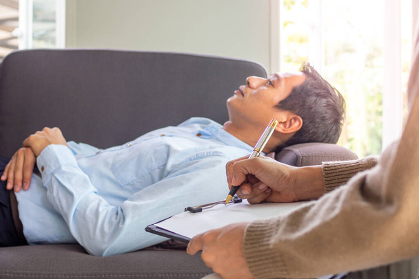Человек с психическими заболеваниями спит с расслабленной осанкой, консультируется и слушает руководящие принципы, чтобы решить болезнь психиатра. - Фото, изображение
