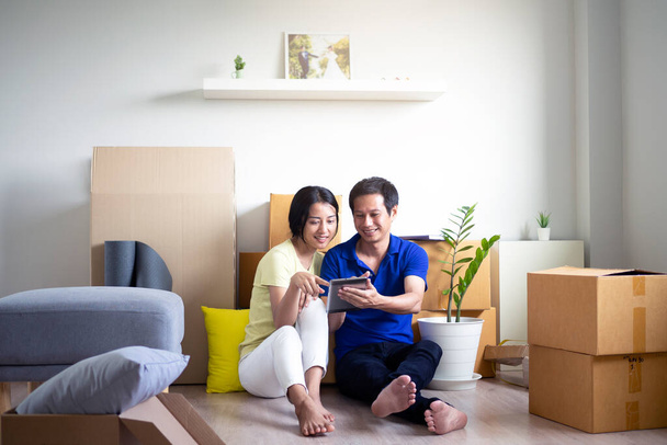 Una giovane coppia asiatica felice si trasferisce in una nuova casa. - Foto, immagini