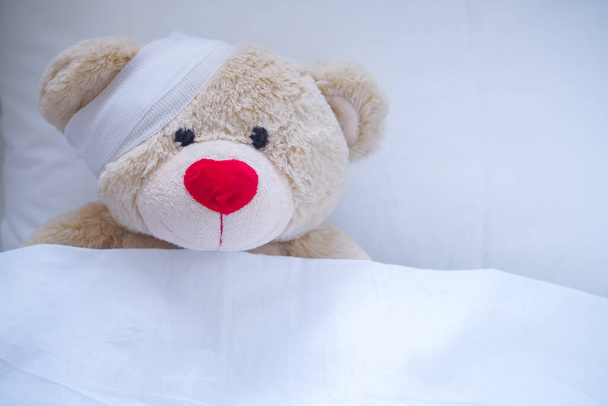 Creamy teddy bear injured in a wound after an accident - Фото, изображение