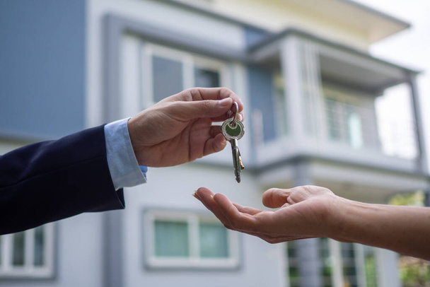 Οι εγχώριοι αγοραστές παίρνουν τα κλειδιά από τους πωλητές. Πουλήστε το σπίτι σας, νοικιάστε σπίτι και αγοράστε ιδέες. - Φωτογραφία, εικόνα