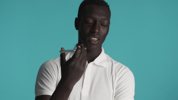 Ελκυστικό κομψό Αφροαμερικανός τύπος ηχογράφηση φωνητικό μήνυμα στο smartphone πάνω από πολύχρωμο φόντο - Πλάνα, βίντεο