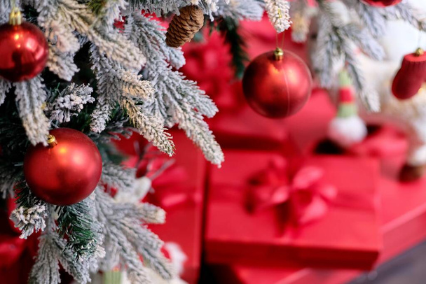 horní pohled na červené koule na vánoční strom. rozmazat červené dárkové krabice na zemi  - Fotografie, Obrázek