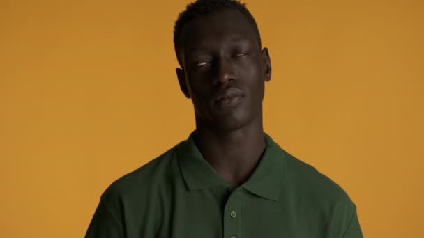 Young annoyed African American man rolling his eyes over colorful background. Weary expression - Video