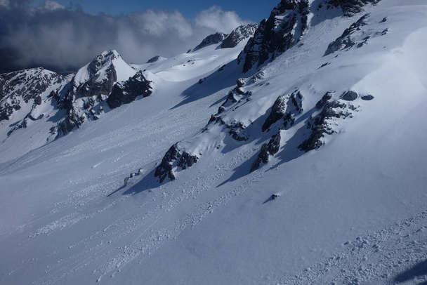Закрыть белый склон снежной горы Нефритовый Дракон в Юньнань Китай. серые темные горные породы покрытые гладким белым снегом - Фото, изображение