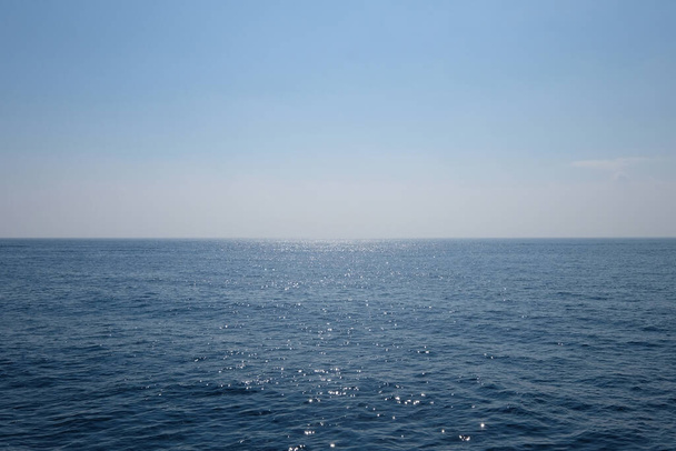 απέραντος βαθύς μπλε θαλάσσιος ορίζοντας. ειρηνική επιφάνεια του ωκεανού με αντανάκλαση φωτός. απλότητα. - Φωτογραφία, εικόνα